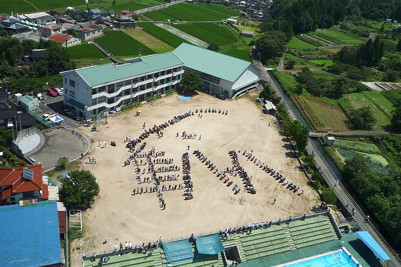 記念空撮写真のため、隼小学校の校庭に全員で描いた『隼・八・八』の人文字とバイク文字。
